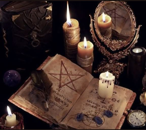Libro, espejo y velas encendidas